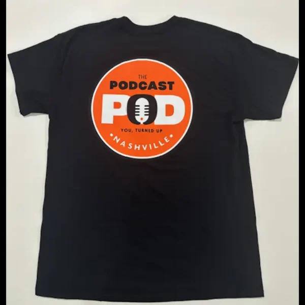 Back of black Podcast Pod Nashville t-shirt with large circular orange logo featuring microphone and "You, Turned Up" slogan