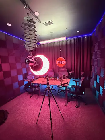 Interior view of The Podcast Pod recording studio in Brentwood, TN with colorful LED lighting, soundproof walls, and professional podcast equipment