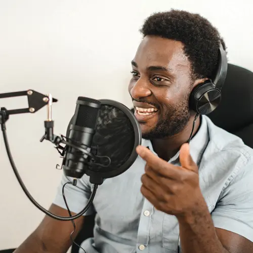 Smiling podcaster recording with headphones and microphone at professional studio near Forest Hills, TN at The Podcast Pod in Brentwood