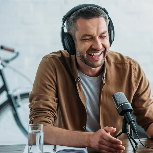 Smiling male podcaster recording with headphones and microphone at a professional podcast studio near Franklin, TN at The Podcast Pod in Brentwood