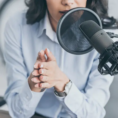 Woman speaking into professional podcast microphone in studio near Nashville, TN at The Podcast Pod in Brentwood