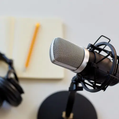 Podcast microphone with headphones and notepad on desk in professional studio near Nolensville, TN at The Podcast Pod in Brentwood
