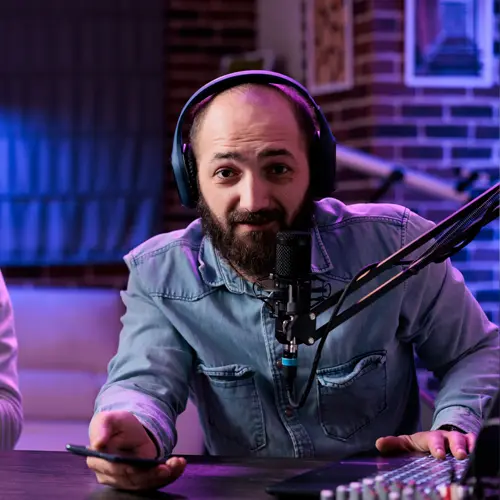 Bearded man podcasting with headphones and microphone at The Podcast Pod near Oak Hill, TN